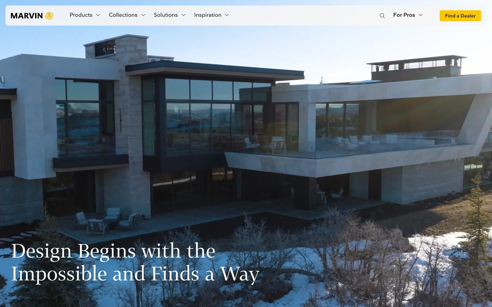 The Marvin homepage: a modern house with walls of glass in snow, under a header with Products, Collections, For Pros and a yellow Find a Dealer button.