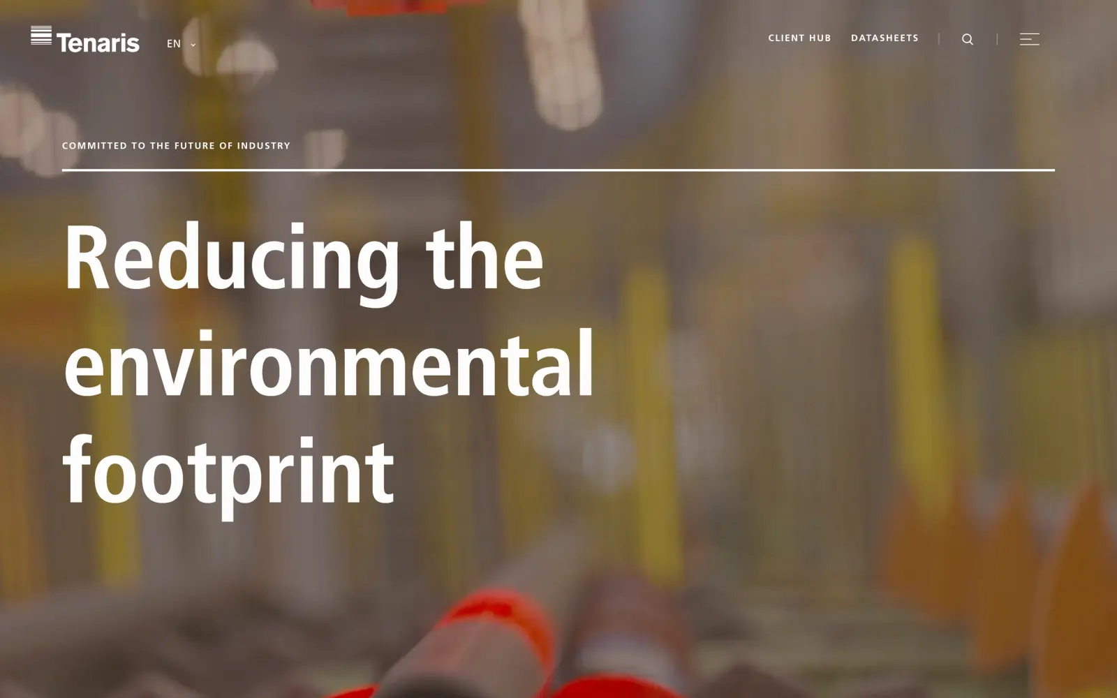 The Tenaris homepage: the headline Reducing the environmental footprint in very large type over blurred mill footage, with Client Hub and Datasheets in the header.