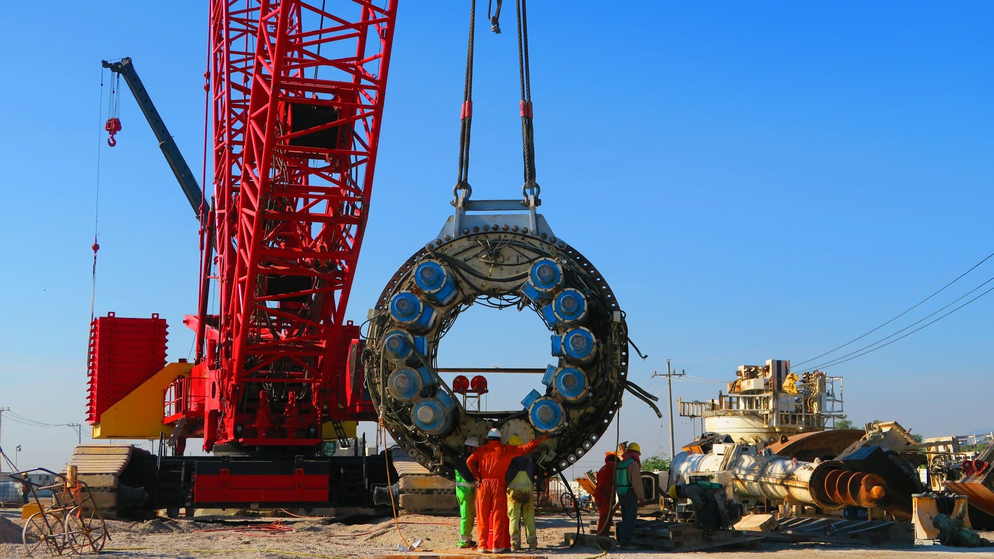 A crawler crane lifting a large steel component on an industrial site